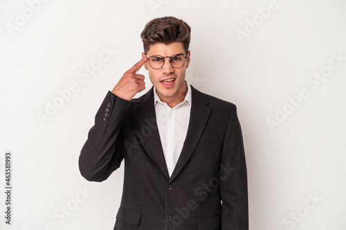 Young business caucasian man isolated on white background showing a disappointment gesture with forefinger.