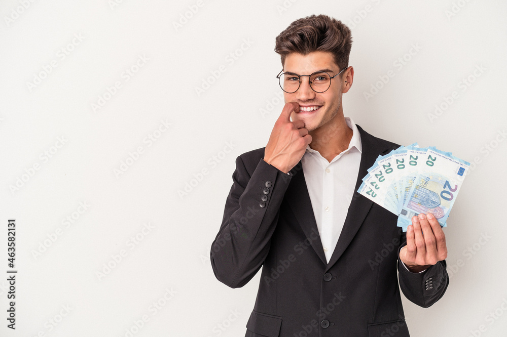Young business caucasian man holding banknotes isolated on white background relaxed thinking about something looking at a copy space. Young business caucasian man holding banknotes isolated on white background relaxed thinking about something looking at a copy space.