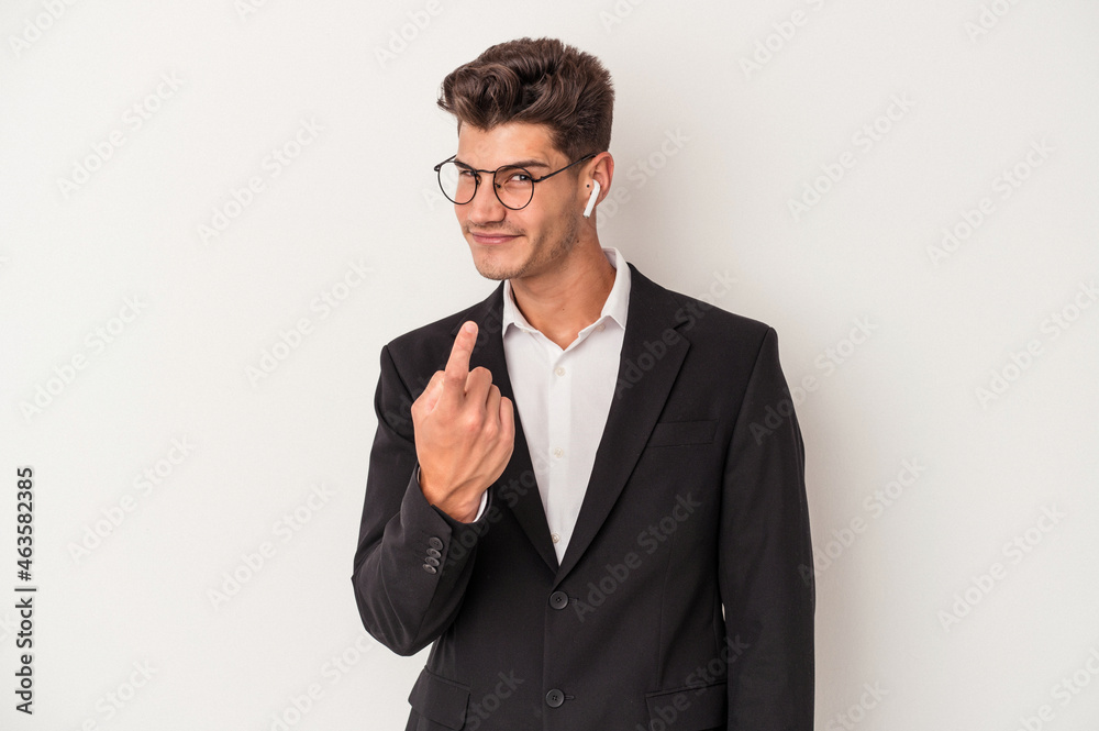 Young business caucasian man wearing headphones isolated on white background pointing with finger at you as if inviting come closer. Young business caucasian man wearing headphones isolated on white background pointing with finger at you as if inviting come closer.