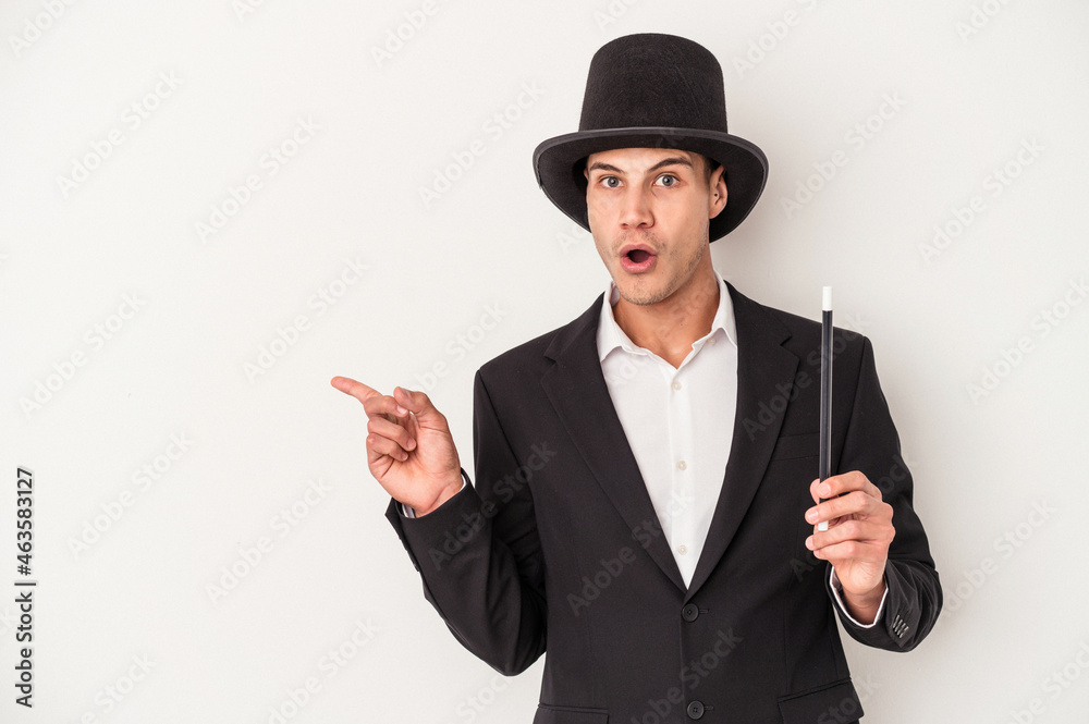 Young magician caucasian man holding a wand isolated on white background pointing to the side Young magician caucasian man holding a wand isolated on white background pointing to the side