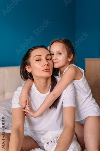 mom and daughter in bed in the morning, daughter hugs mom, mom strokes daughter © Дмитрий Бесов
