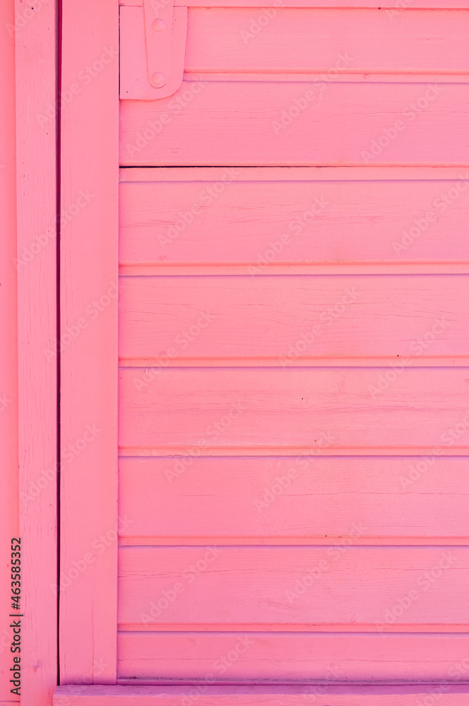 Weathered wooden plank painted in pink color