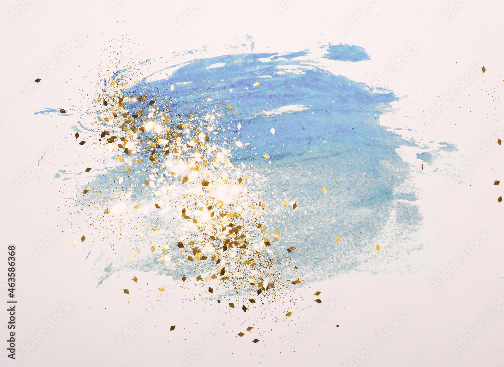 Golden glitter on abstract blue watercolor splashes in vintage nostalgic colors