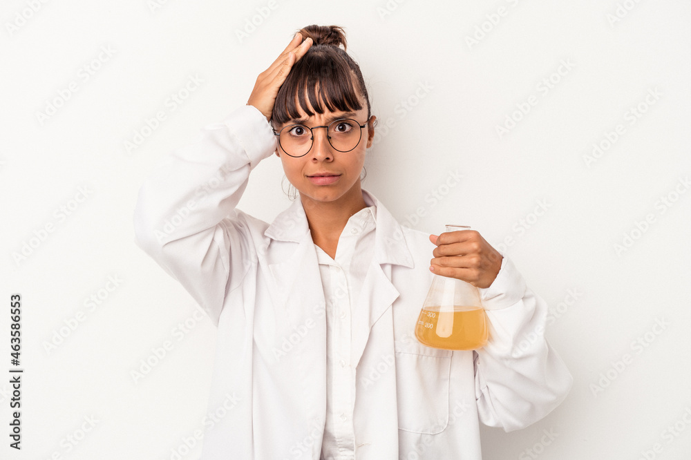 Young mixed race scientist woman holding a test tube isolated on white background being shocked, she has remembered important meeting. Young mixed race scientist woman holding a test tube isolated on white background being shocked, she has remembered important meeting.