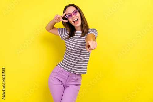 Photo of hooray millennial brunette lady point you wear eyewear white t-shirt isolated on yellow background