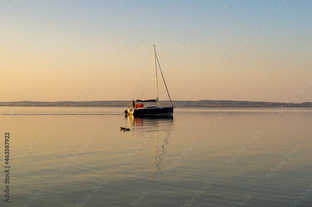 Beautiful water landscape with yacht and sail at sunset