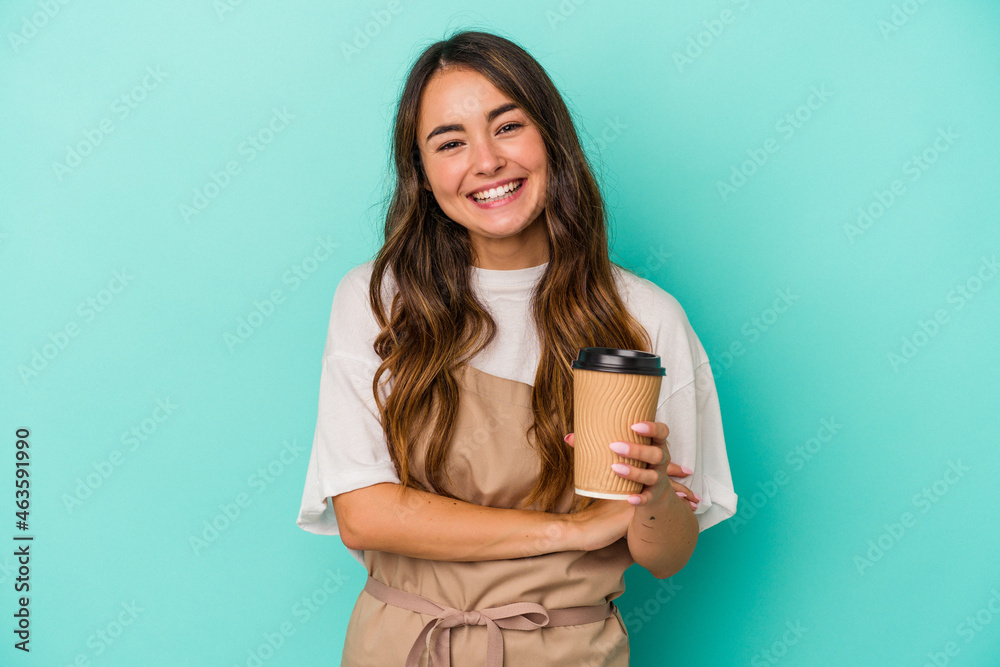 Young caucasian store clerk woman holding a takeaway coffee isolated on blue background laughing and having fun. Young caucasian store clerk woman holding a takeaway coffee isolated on blue background laughing and having fun.