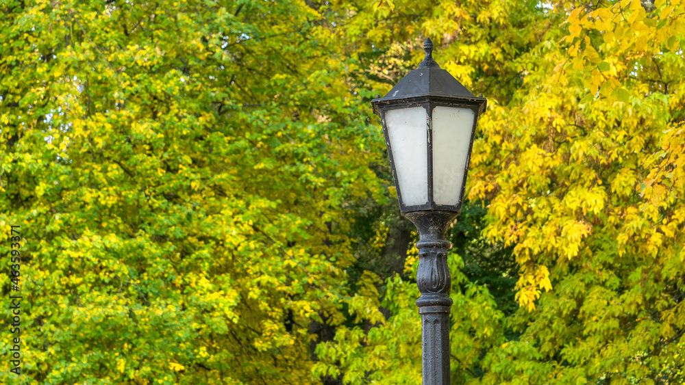 Lantern against autumn yellow trees. Street lamp in the autumn park. Beautiful Autumn Landscape With Old Fashion Lamp. Lantern against autumn yellow trees. Street lamp in the autumn park. Beautiful Autumn Landscape With Old Fashion Lamp.