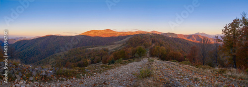 Rocky road in the mountains in the early morning. Golden autumn, panorama of a beautiful mountain landscape