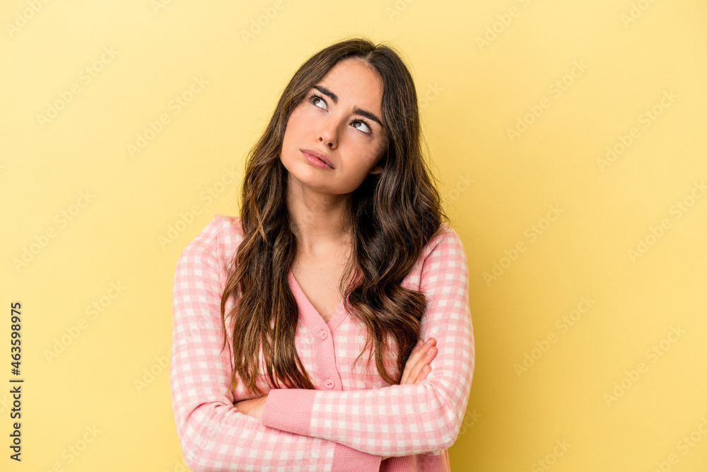 Young caucasian woman isolated on yellow background tired of a repetitive task.