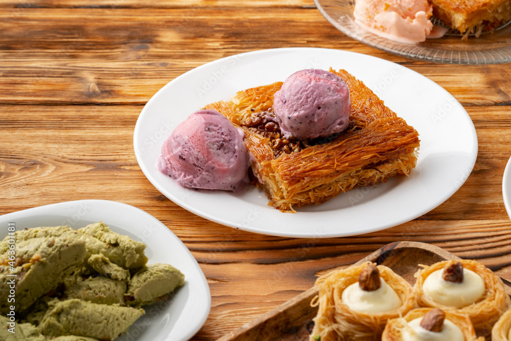 Turkish dessert kunefe served with ice cream on wooden background