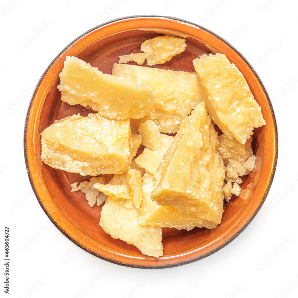 Pieces of parmesan cheese in a clay rustic bowl isolated on white background. Pieces of parmesan cheese in a clay rustic bowl isolated on white background.