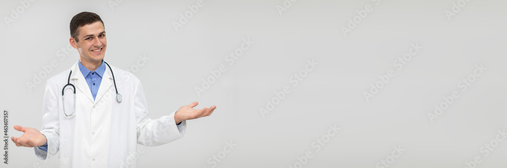A smiling doctor spreads his arms out to the sides and leaves the choice to the patient. Panoramic view. A smiling doctor spreads his arms out to the sides and leaves the choice to the patient. Panoramic view.