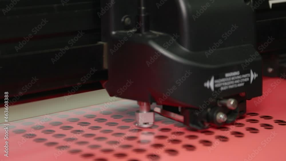 A wide shot of a plotter cutting out round stickers. A wide shot of a plotter cutting out round stickers.