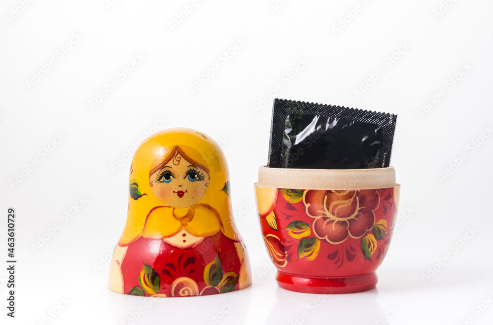 Condom in small pack placed inside single Russian wooden doll. A concept for 'population control'.