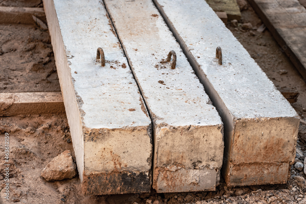 Reinforced concrete beams for building structures stacked at a construction site. Reinforced concrete beams for building structures stacked at a construction site.