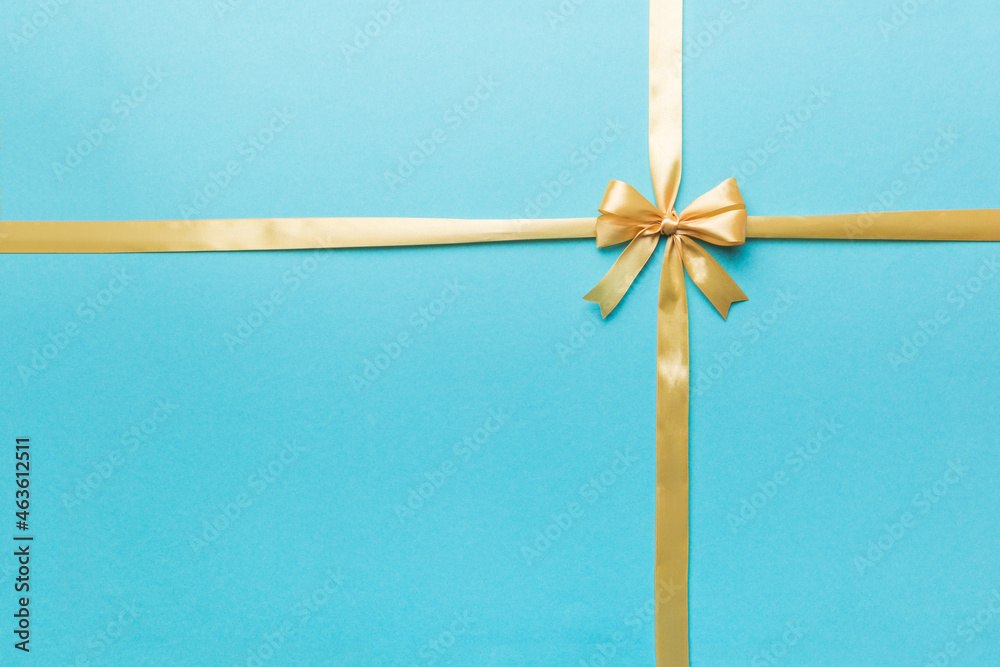 Top view of gold ribbon rolled and yellowbow isolated on colored background. Flat lay with copy space Top view of gold ribbon rolled and yellowbow isolated on colored background. Flat lay with copy space