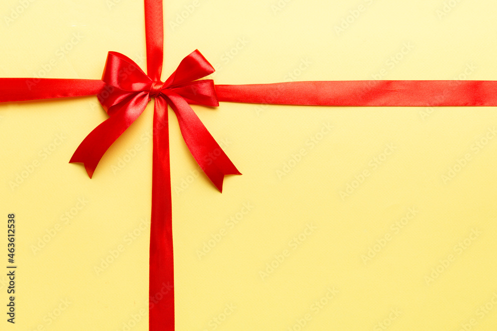 Top view of Red ribbon rolled and red bow isolated on colored background. Flat lay with copy space Top view of Red ribbon rolled and red bow isolated on colored background. Flat lay with copy space