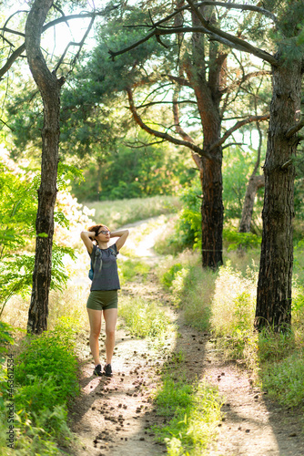 A young woman walks along a forest path.