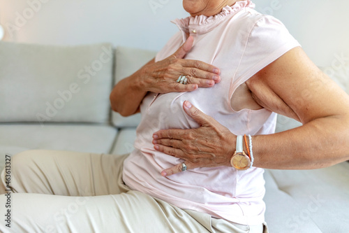 Cropped shot of a beautiful senior woman is suffering from pain in the breast. Adult woman doing breast self-examination at home.