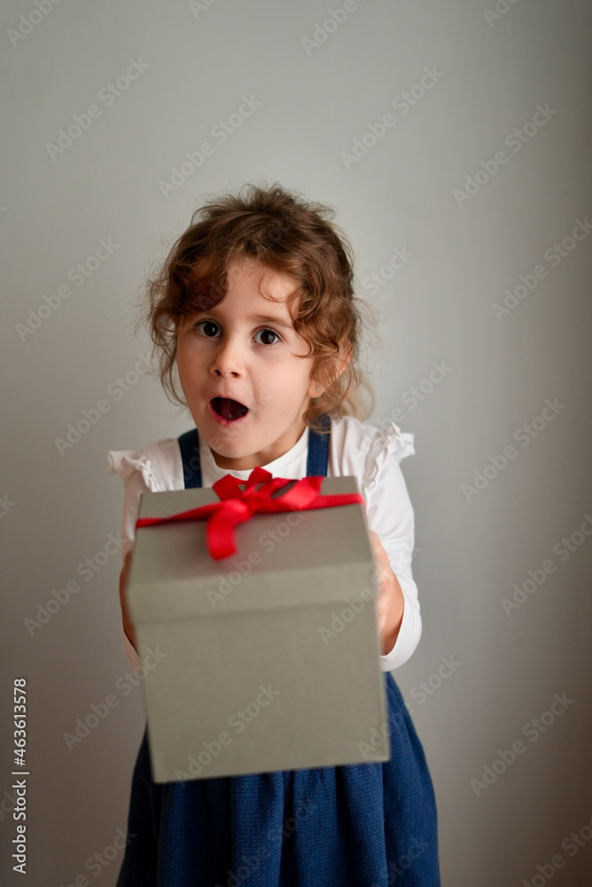 Little happy girl with a funny face surprised by a Christmas gift .Happy laughing child girl with Christmas gift at home. Christmas surprise. Christmas holidays concept, New Years Eve Little happy girl with a funny face surprised by a Christmas gift .Happy laughing child girl with Christmas gift at home. Christmas surprise. Christmas holidays concept, New Years Eve