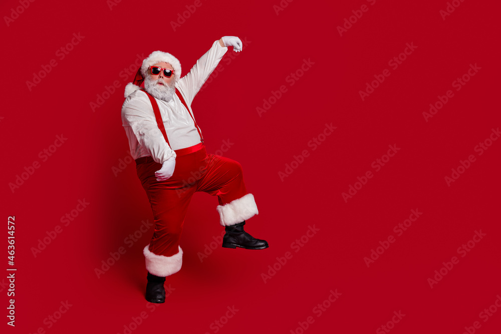 Photo of excited man dance carefree festive x-mas mood wear santa hat costume isolated red color background Photo of excited man dance carefree festive x-mas mood wear santa hat costume isolated red color background