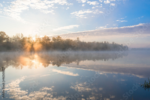 autumn landscape river in the morning fog over the water. panorama of the river in autumn. the yellow trees are reflected in the water