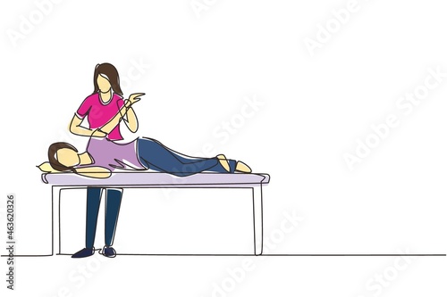 Single continuous line drawing woman patient lying on massage table therapist doing healing treatment massaging injured hand manual physical therapy rehabilitation concept. One line draw design vector