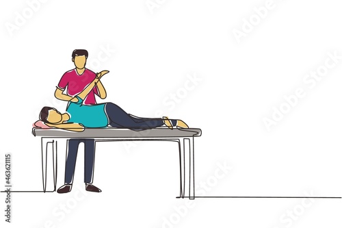 Single one line drawing man patient lying on massage table therapist doing healing treatment massaging injured hand manual physical therapy rehabilitation concept. Continuous line draw design vector