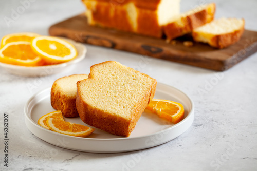Slices of homemade cake with oragnic oranges