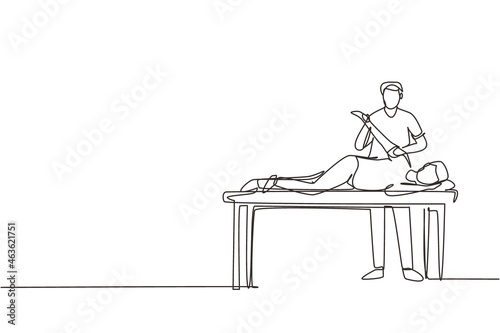 Single one line drawing man patient lying on massage table therapist doing healing treatment massaging injured hand manual physical therapy rehabilitation concept. Continuous line draw design vector