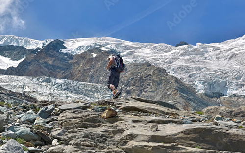 hiker climbing a alpine glacier in summer