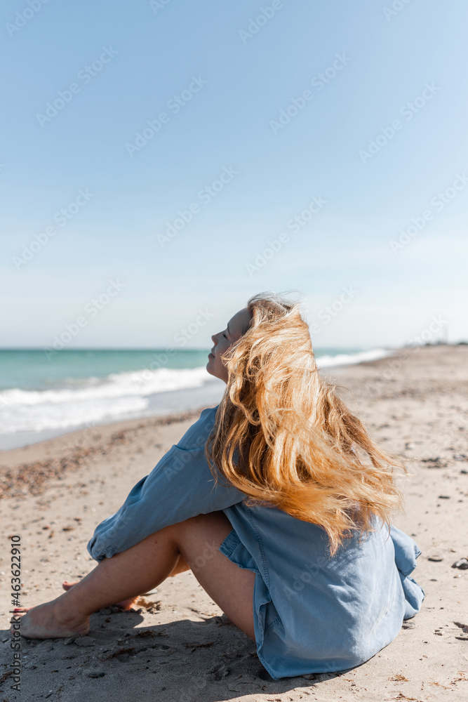 Woman in shirt sitting on beach