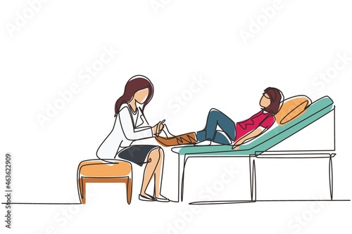 Continuous one line drawing medical doctor bandage broken leg to little girl patient sitting on couch at clinic or traumatology department. Limb fracture. Single line draw design vector illustration