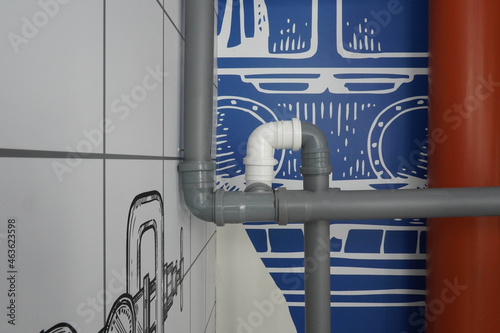 Photo of gray and white pipes on the background of a blue wall of a marine theme