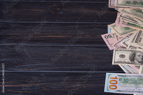 Dollars on a black wood background. Financial savings and income.