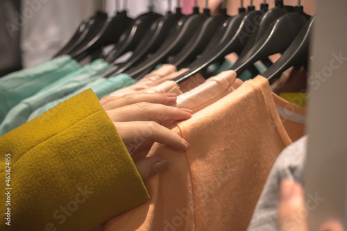 Shopping in big store, hangers with clothes, fashion background photo