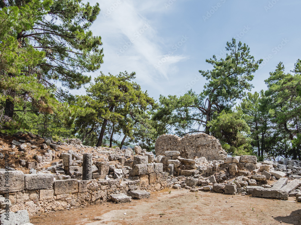 Ruins of ancient city Phaselis. Stones of damaged buildings and archaeological excavations outdoors on a sunny day. Turkey.