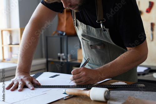 Cropped shot of male artisan wearing apron while drawing patterns in tanners workshop, copy space photo