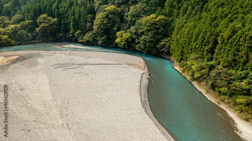 A jade-colored river and white sandbar that curves against the mountains