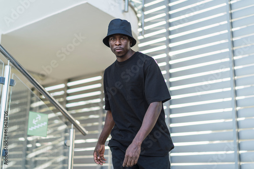 Chico negro atlético posando con ropa urbana en zona urbana