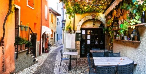 Fototapeta Naklejka Na Ścianę i Meble -  Charming old narrown streets of Italian villages. Malcesine, Garda lake, Italy. Autumn colors, cosy street bars