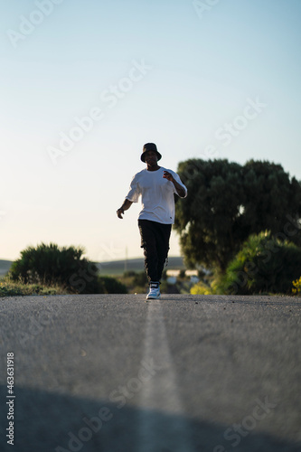 Chico negro atletico con camiseta blanca en carretera abandonada  © MiguelAngelJunquera