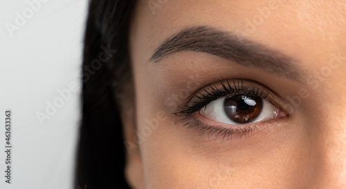 Fototapeta Naklejka Na Ścianę i Meble -  Close-up portrait of young woman with beautiful eyes. Macro cropped photo with attractive female face. Wellness, wellbeing, treatment and therapy concept