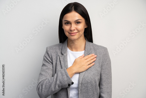 I swear. Portrait of responsible serious businesswoman in business suit holding hand to take oath, promising to be honest, telling truth, pledging allegiance. Studio shot isolated on white background