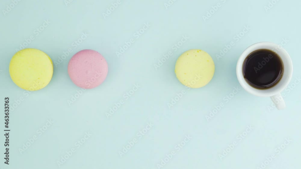 Top view of multicolored French Macarons cookies and a cup of coffee on a pastel blue background Top view of multicolored French Macarons cookies and a cup of coffee on a pastel blue background