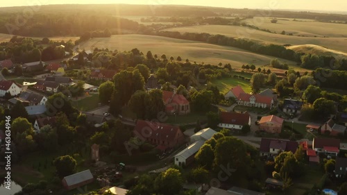 Aerial View in summer over a small village in Mecklenburg-Vorpommern Germany. The fields are yellow and green and the sun is going down. photo