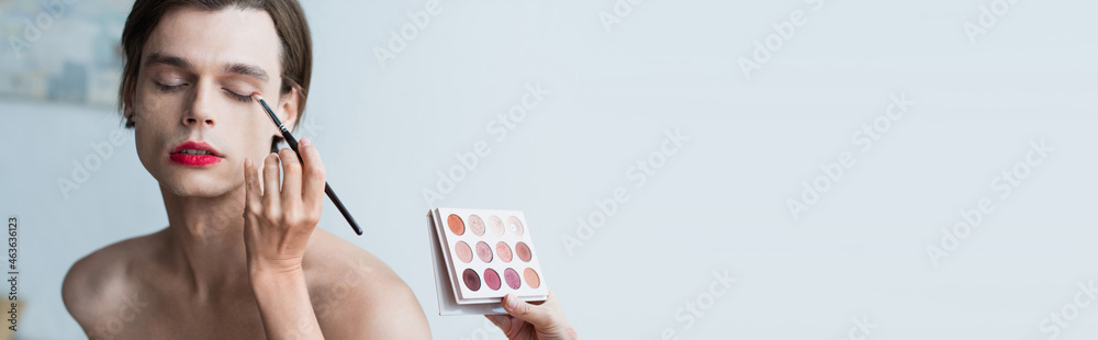 makeup artist applying eye shadow on transgender person, banner