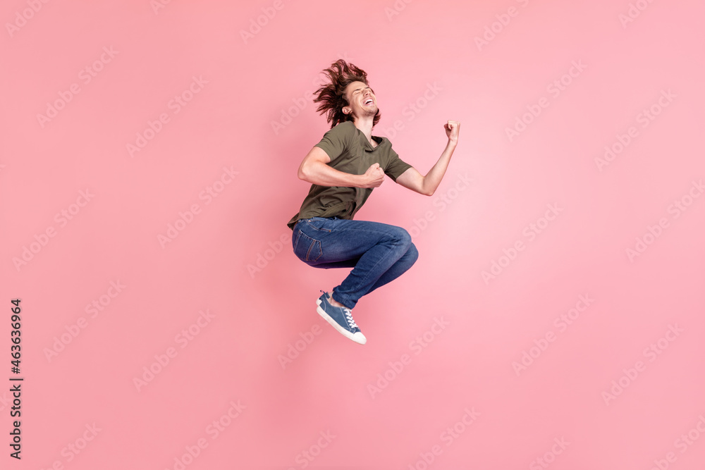 Full length profile side photo of young man jump celebrate victory shocked win lottery isolated over pink color background