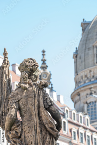 Old statue of a sensual woman warrior, Amazonian, as defender with flag at the Neumarkt in historical and shopping downtown of Dresden, Germany, details, closeup.